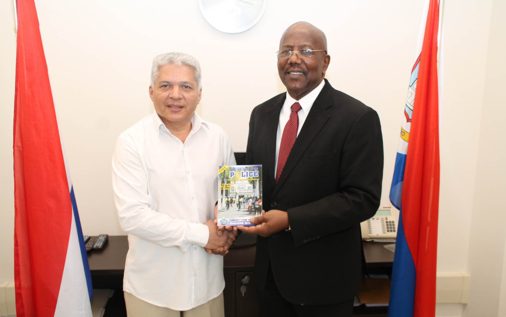 Photo of Robert Espitia and Prime Minister William Marlin holding a magazine